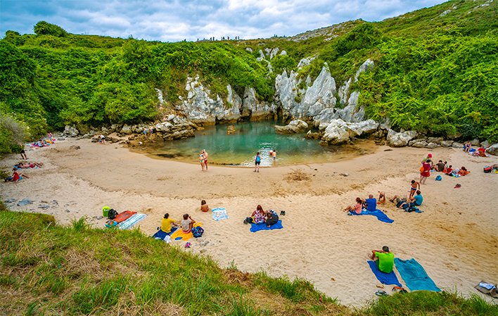 Gente en la playa de Gulpiyuri en Llanes Gente en la playa de Gulpiyuri en Llanes